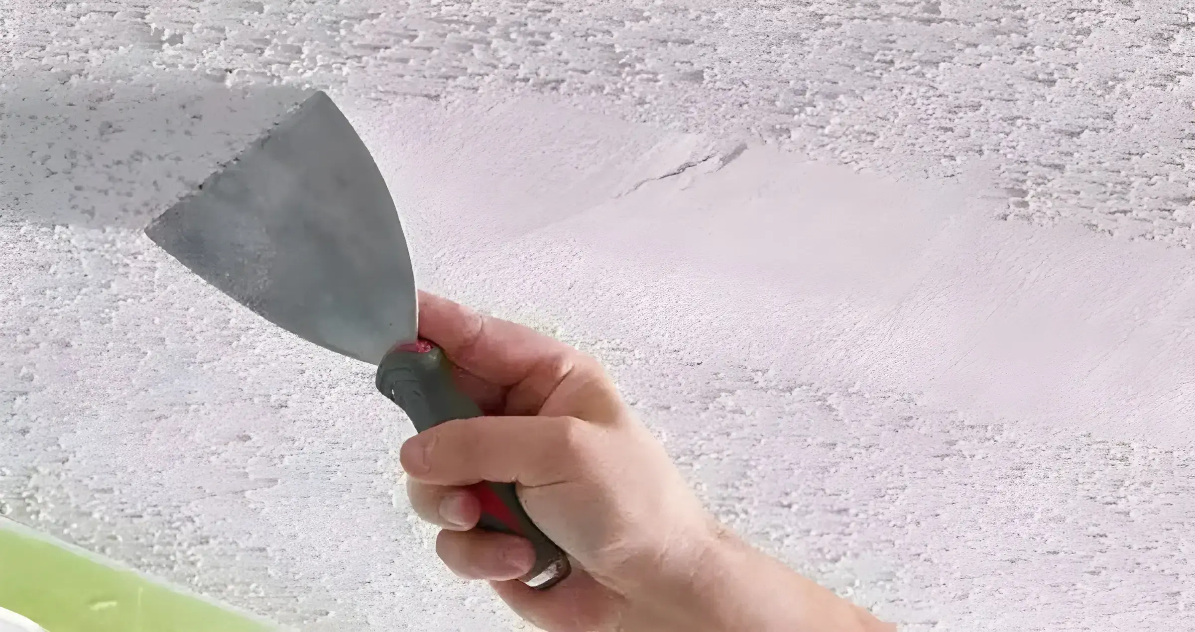 Pintor en Dos Hermanas eliminando el gotelé con espátula para dejar la pared lisa